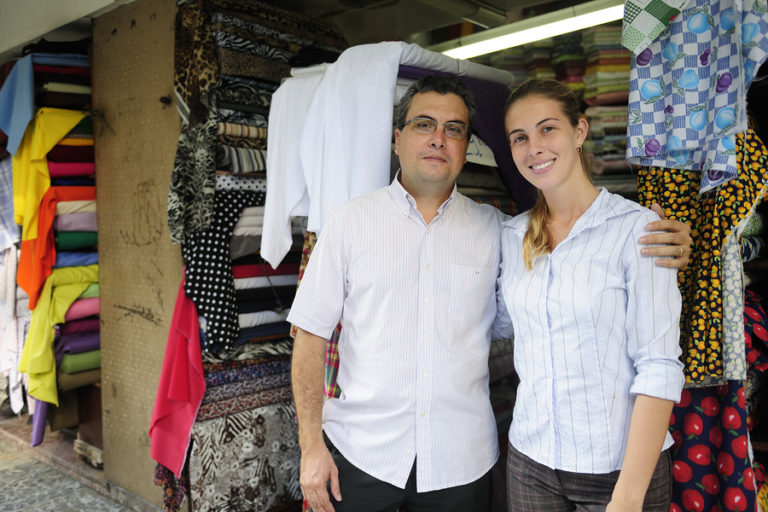 A man and a woman standing in front of their family-owned business.